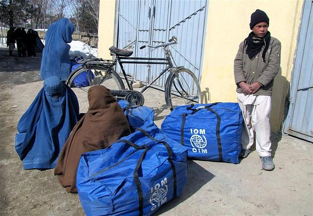 Women from destitute families sit with winter assistance in Ghazni