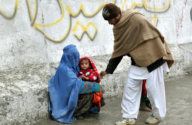 pedestrian gives money to beggar woman