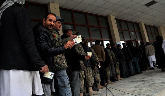 Men in queue show their voting cards