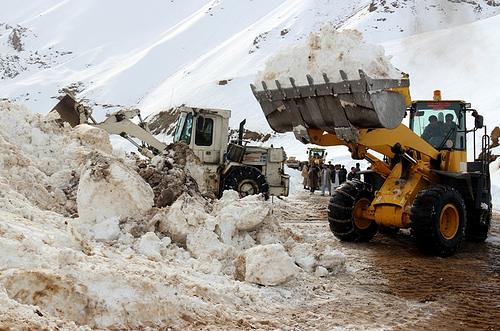 Bulldozers remove snow to open a read