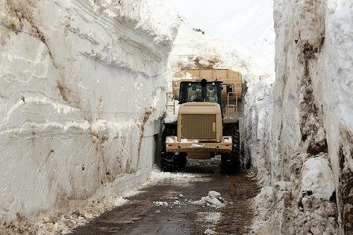 Bulldozer removes piles of snow