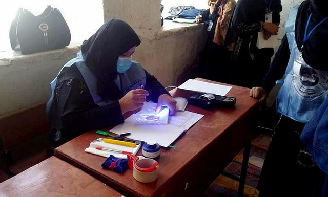 Female worker of IEC voting process
