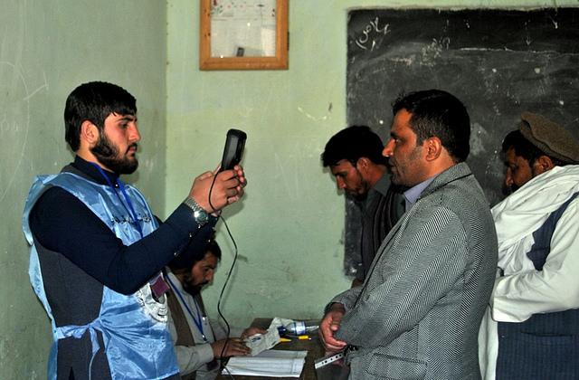 IEC worker takes picture of voter