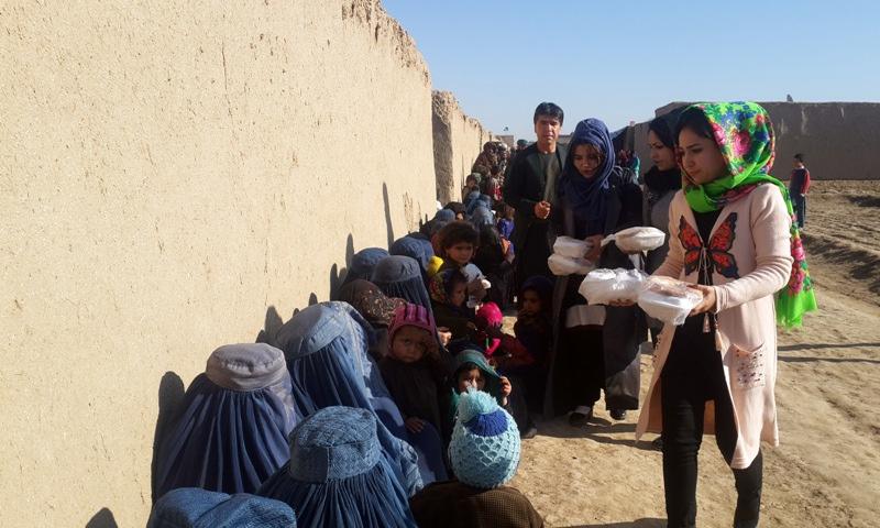Young girls provide food to displaced families