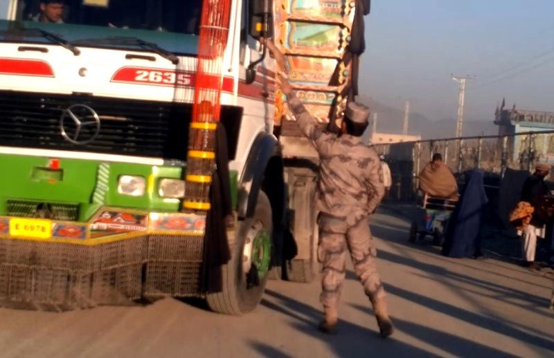 Policeman taking money from a truck driver in Torkham