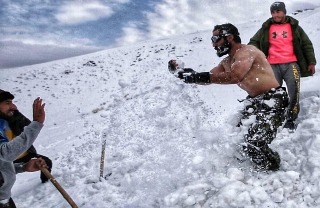 یک ورزشکار درغور، به هدف جلب کمک‌ها برای نیازمندان، روی برف و یخ تمرین اجرا می‌کند