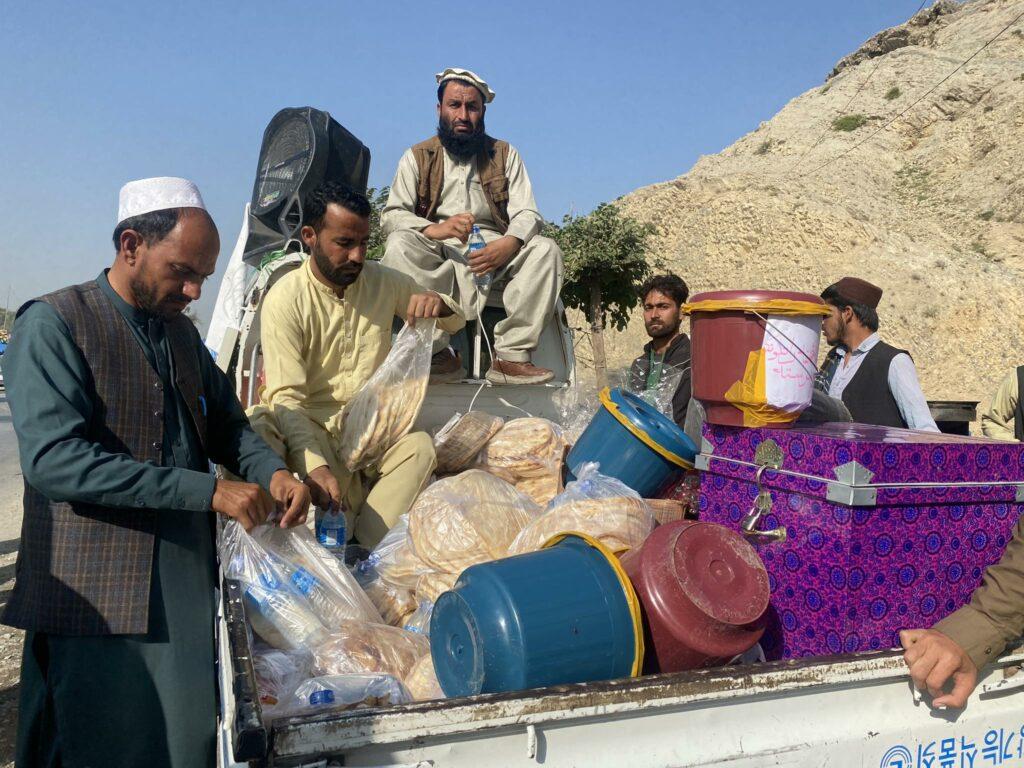 Shinwari tribe people distribute food, water to returnees in Nangarhar