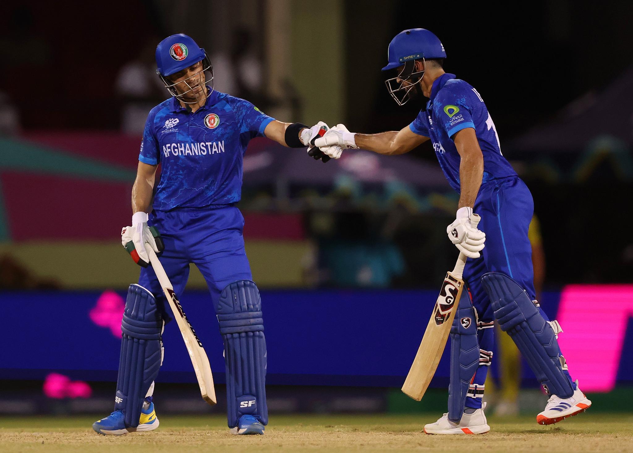 GEORGETOWN, GUYANA - JUNE 03: Rahmanullah Gurbaz of Afghanistan is congratulated by teammate Ibrahim Zadran after scoring a half century during the ICC Men's T20 Cricket World Cup West Indies & USA 2024 match between Afghanistan  and Uganda at  Providence Stadium on June 03, 2024 in Georgetown, Guyana. (Photo by Darrian Traynor-ICC/ICC via Getty Images)