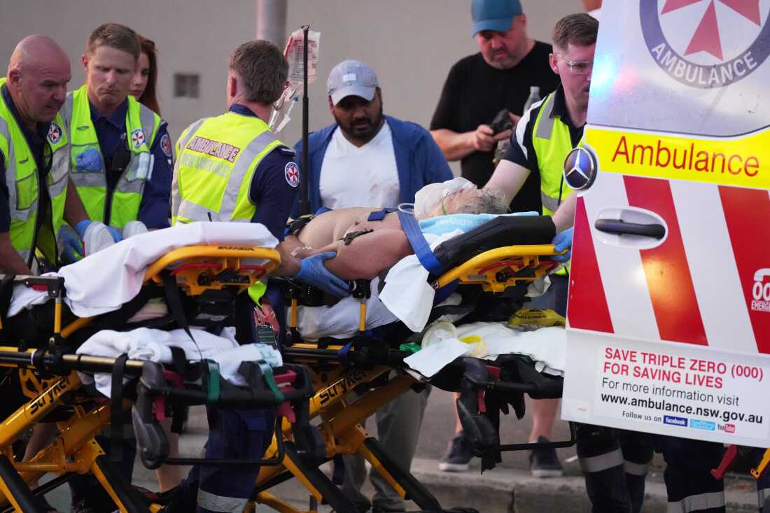 Emergency workers transport a person on a stretcher after a reported shooting at Bondi Beach in Sydney, Sunday, Dec. 14, 2025. (AP Photo/Mark Baker)